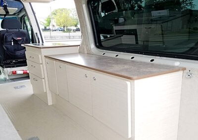 custom interior to a van, builtin cabinets with counter tops for storage