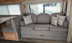 Grey reupholstered couch with custom made pillows